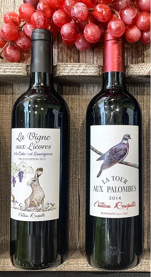 Deux bouteilles de vin rouge avec des étiquettes d'animaux, sur fond de bois et de raisins Le Passage près d'Agen dans le Lot-et-Garonne 47