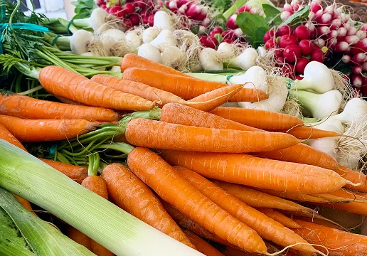 Un étal de marché avec des carottes, des poireaux, des oignons nouveaux et des radis frais Le Passage près d'Agen dans le Lot-et-Garonne 47